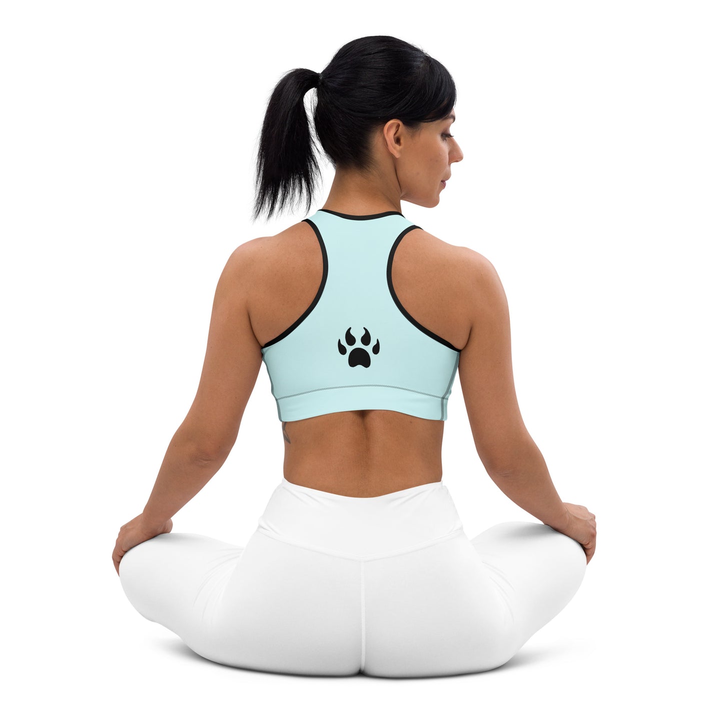 a woman sitting in a yoga pose wearing a Padded Sports Bra Teal from Sweetest Paw with a paw print on it.