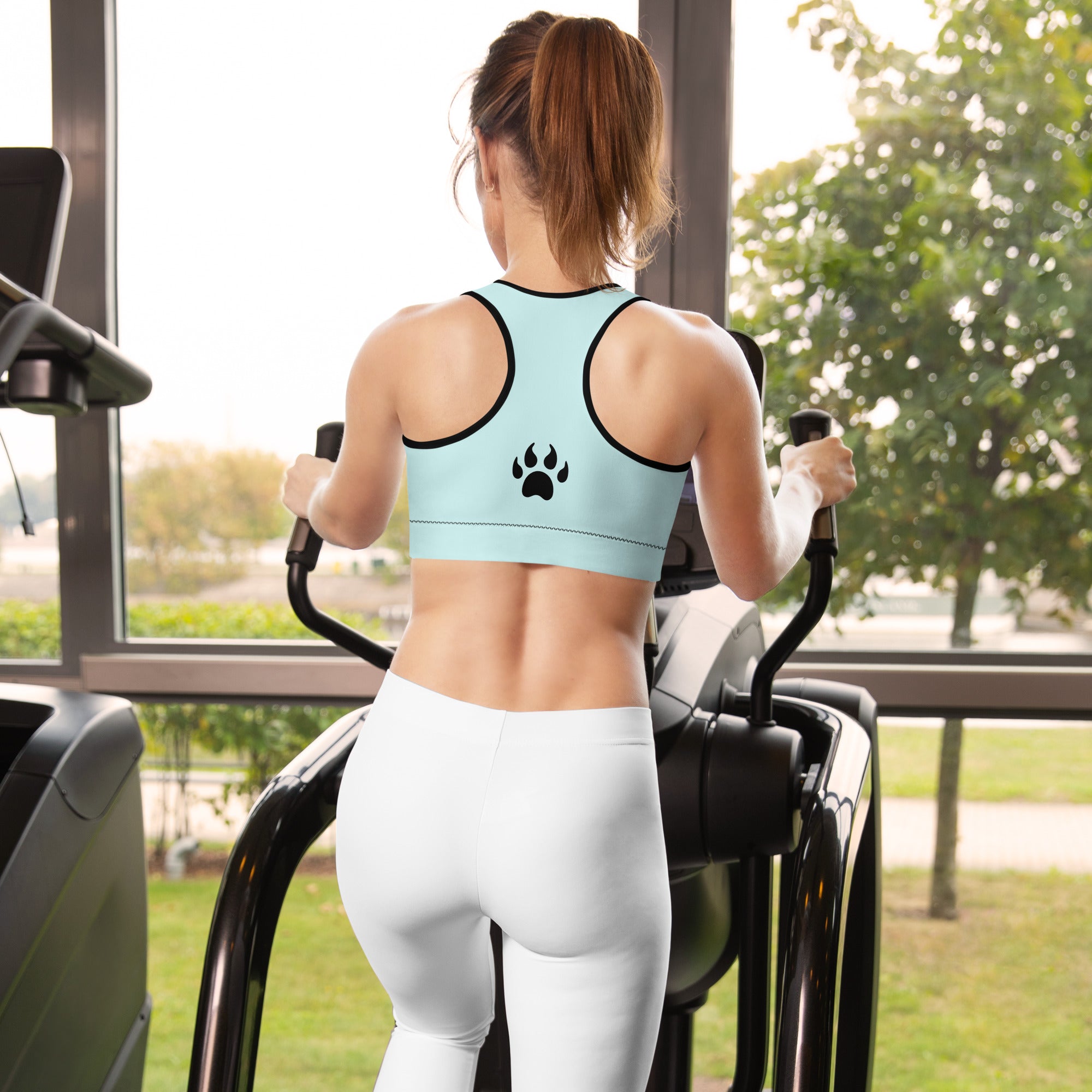 a woman on a treadmill with a Sweetest Paw Padded Sports Bra Teal on her back.