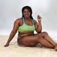 a black woman sitting on the sand in a Sweetest Paw Padded Sports Bra Multi.