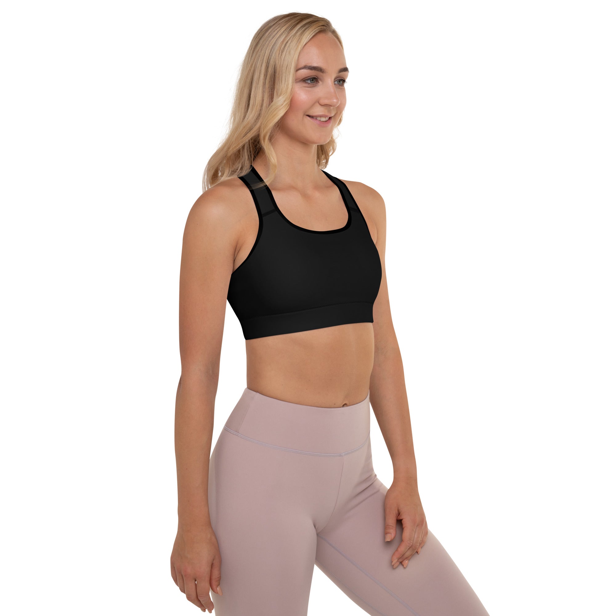 A woman wearing a Sweetest Paw Padded Sports Bra Black top and pink leggings.