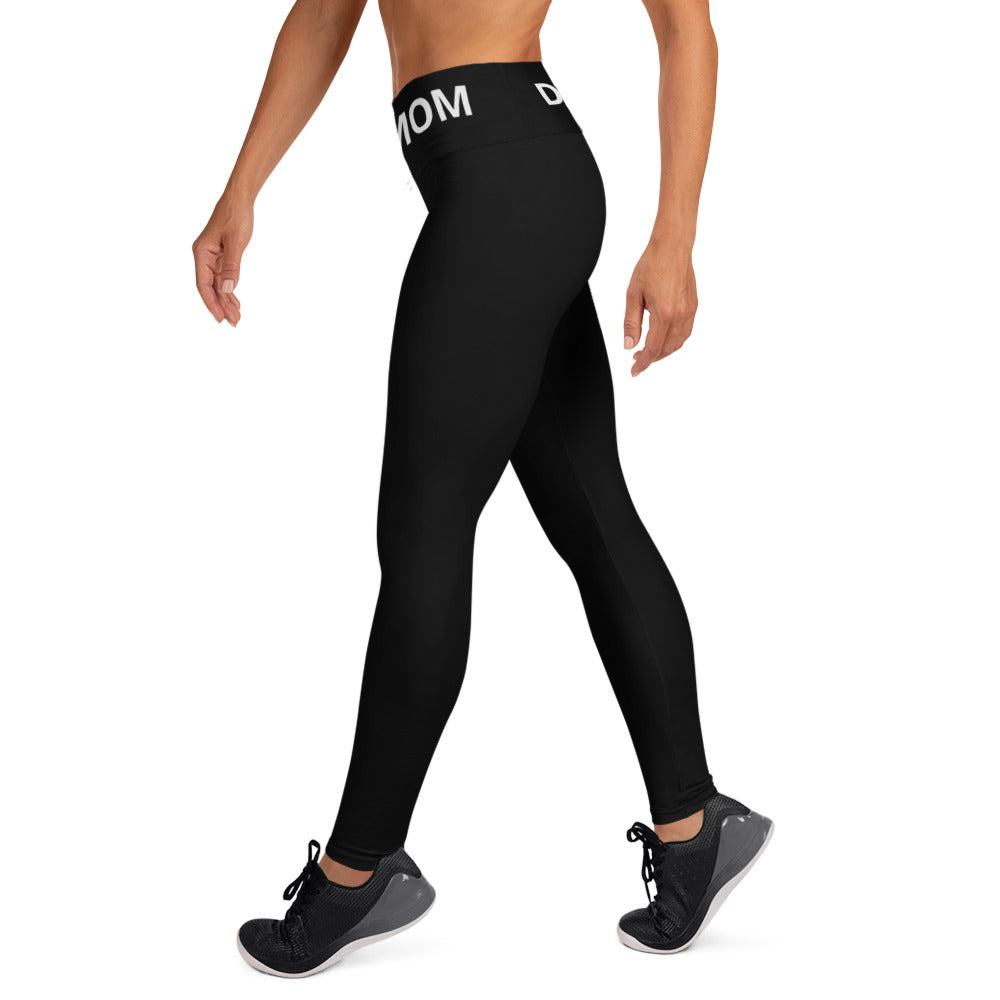 A woman wearing Sweetest Paw Yoga Leggings Black with the word mom on them.