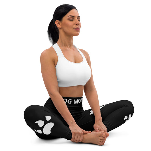 A woman in yoga pose with Sweetest Paw's Black PawPrint leggings.