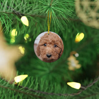 A photo of a poodle hanging on a printify custom-made Ceramic Ornament.